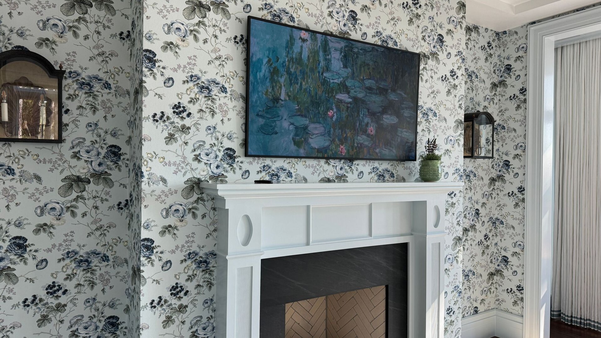 Elegant living room with floral wallpaper and a white fireplace