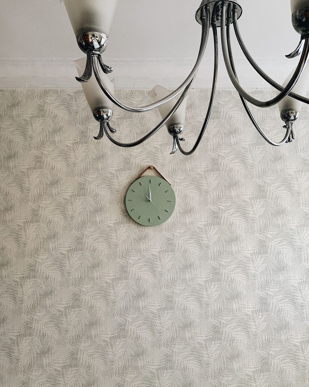Patterned wall with a chandelier and wall clock