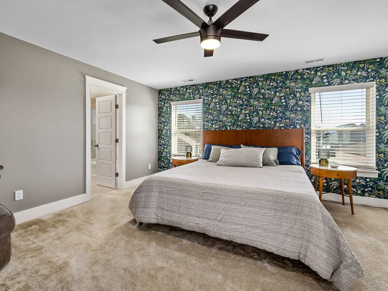 Bedroom with a floral feature wall and an accent armchair
