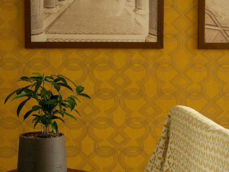 Wall finished with a gold geometric patterned wallpaper